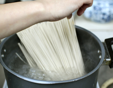 麺は大きめ鍋に約2Lのお湯を充分に沸騰させ、おそば1袋（3人前分）を軽くほぐしながら入れます。